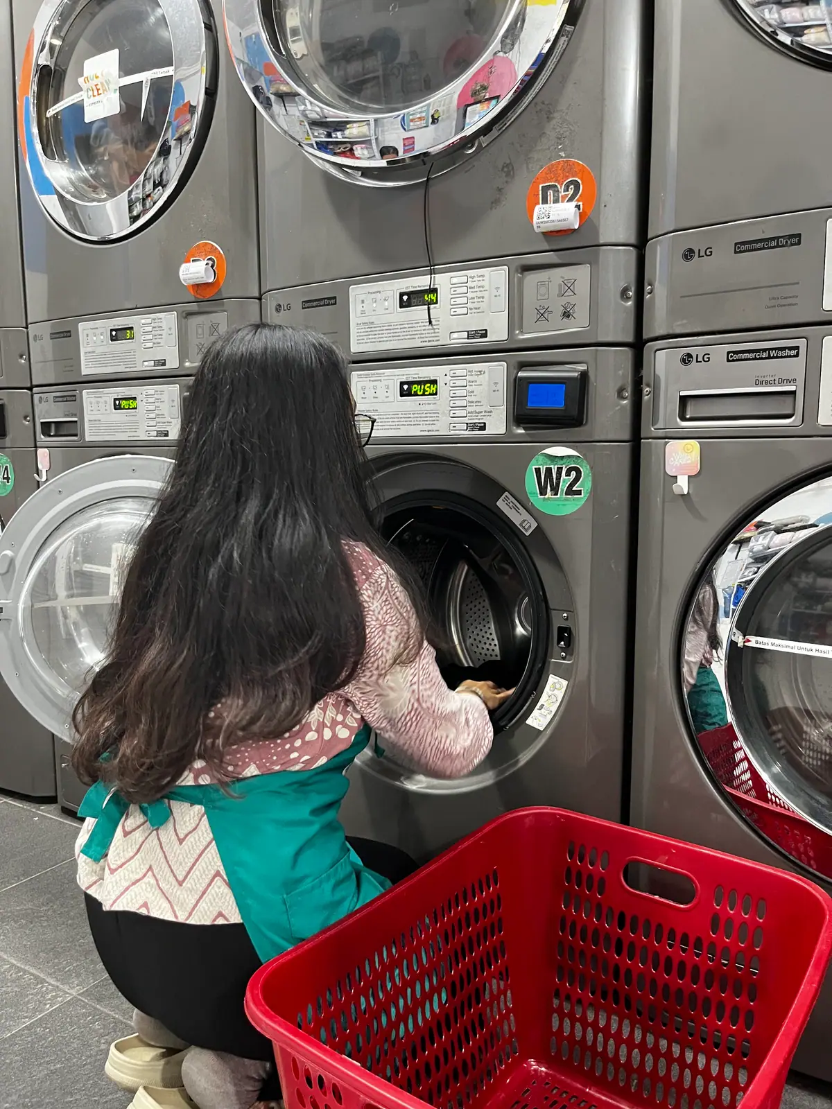 Staf Holyclean memasukkan cucian ke dalam mesin cuci