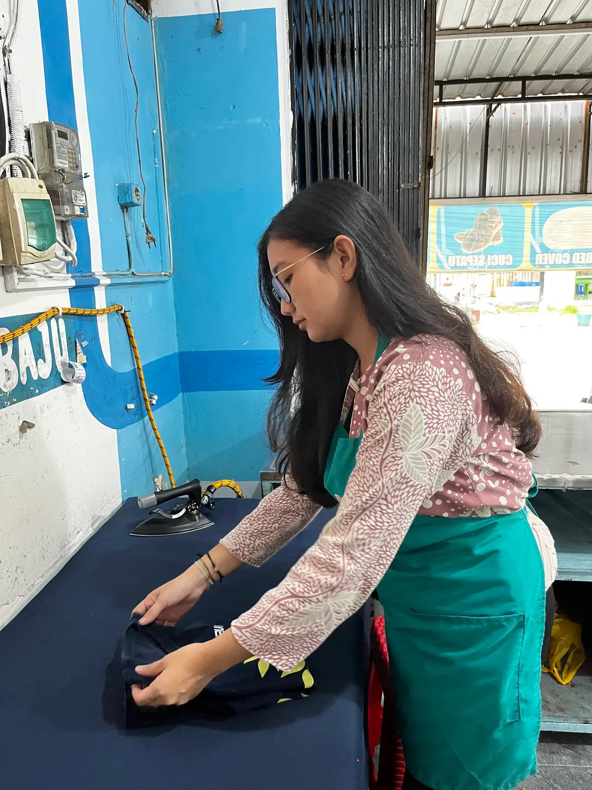 Staf Holyclean melipat pakaian bersih di meja